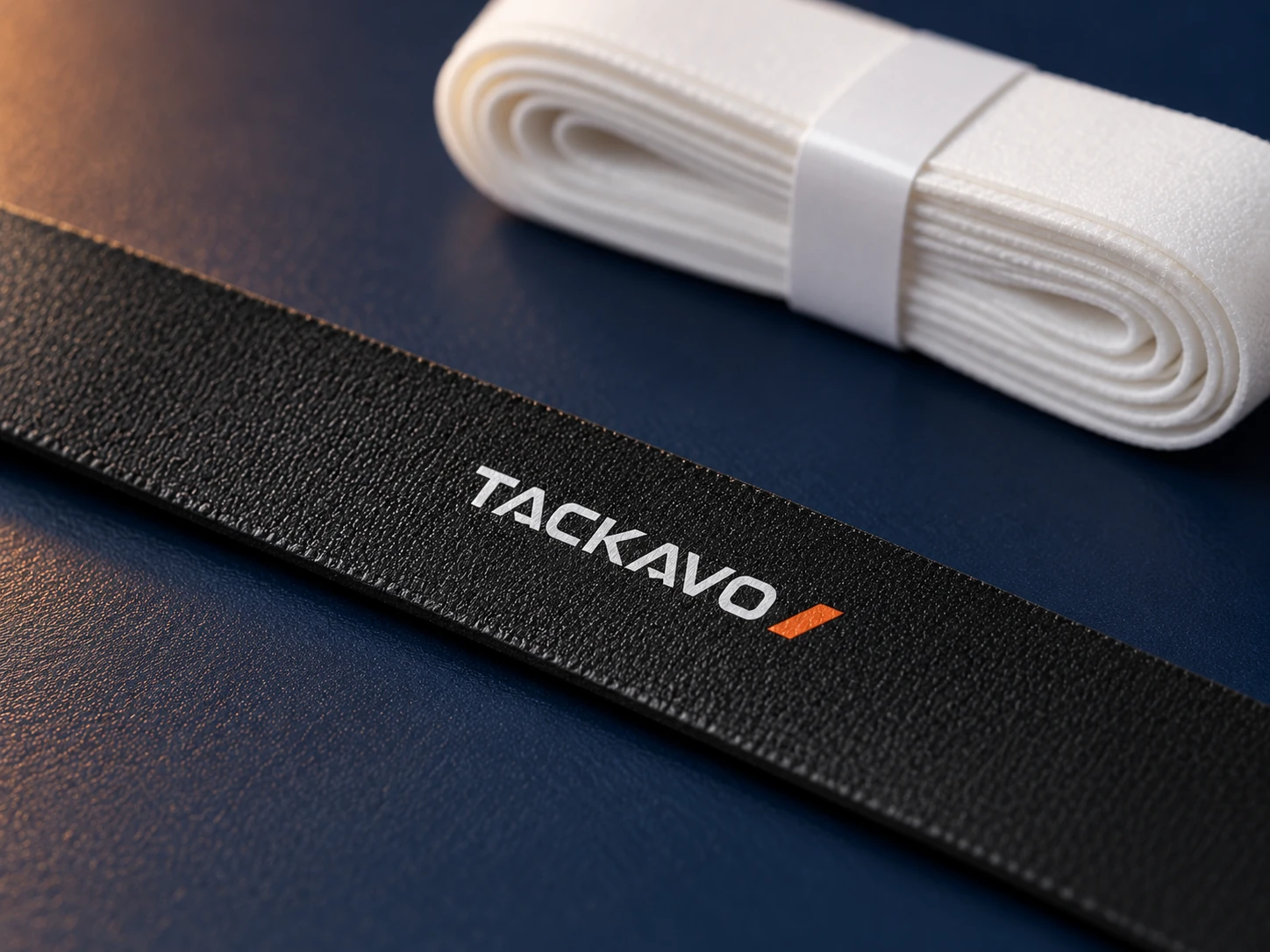 White Tackavo logo printed on a textured black grip strip White Tackavo logo printed on a textured black grip strip