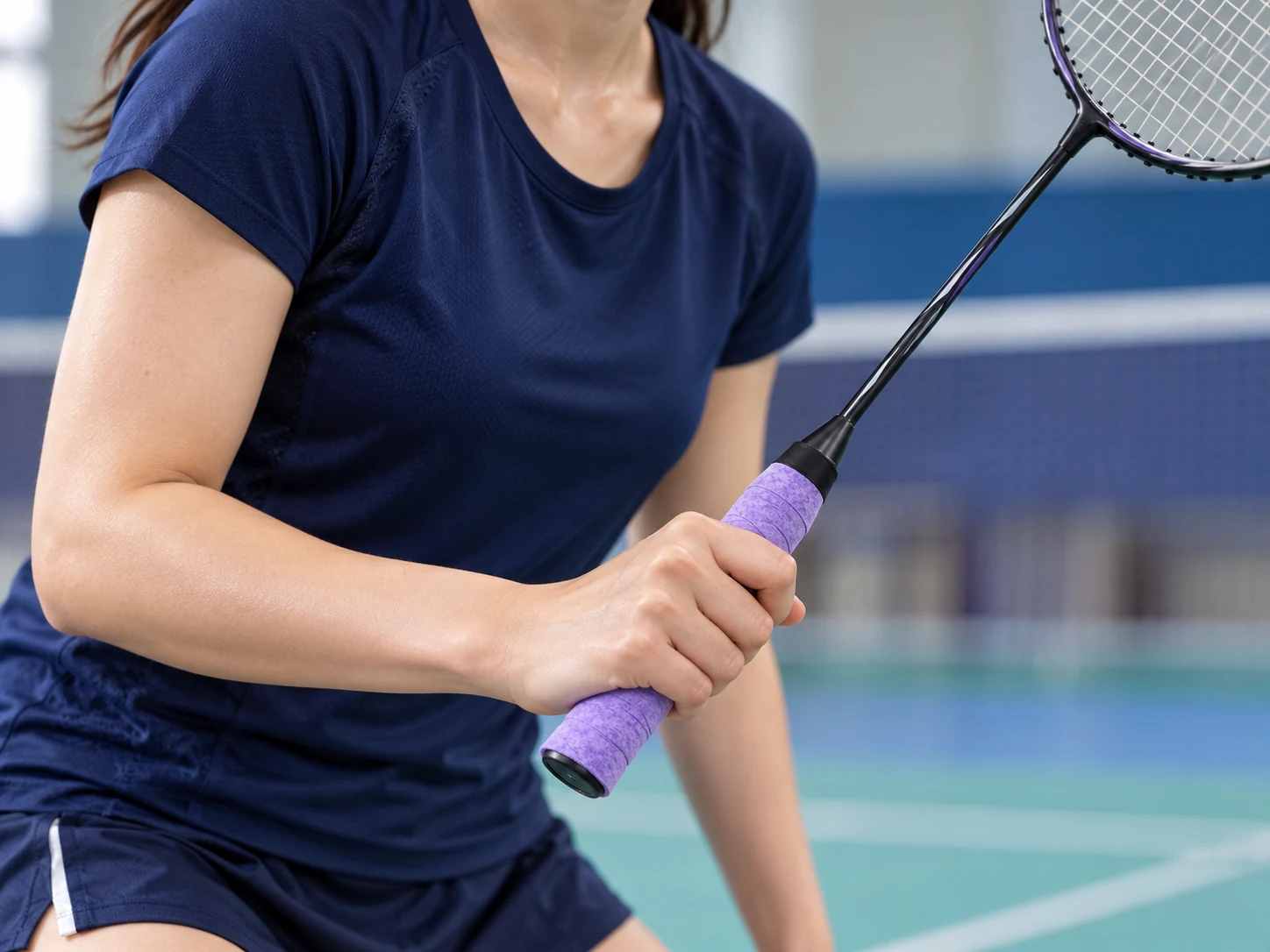 A tennis player holding a racket with OG-D02 purple perforated dry overgrip