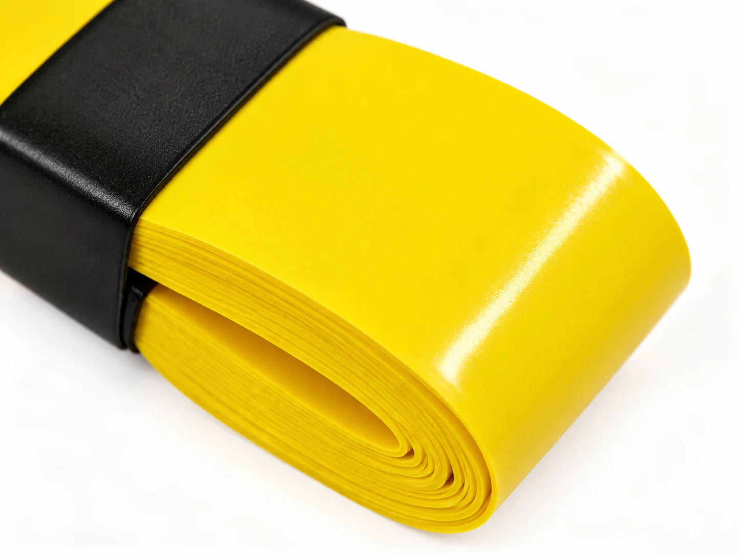 Close-up of the OG-MT01/MT02 yellow mild-tack overgrip surface and roll edge