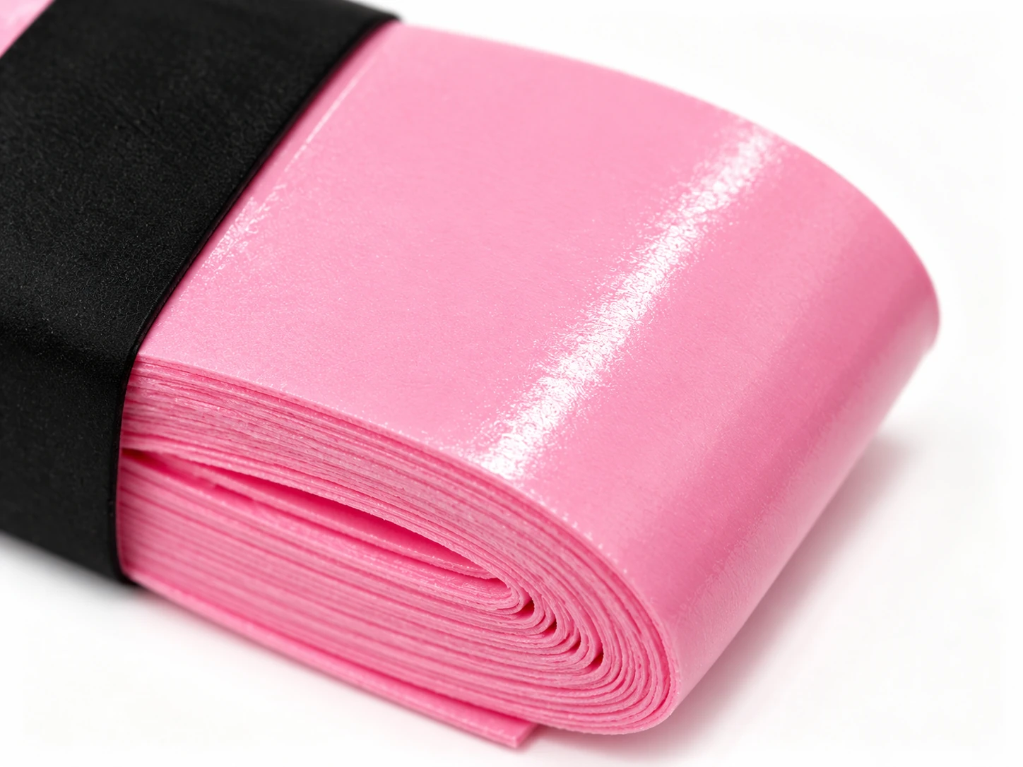 Close-up of the OG-T01 pink soft tacky overgrip surface and roll edge