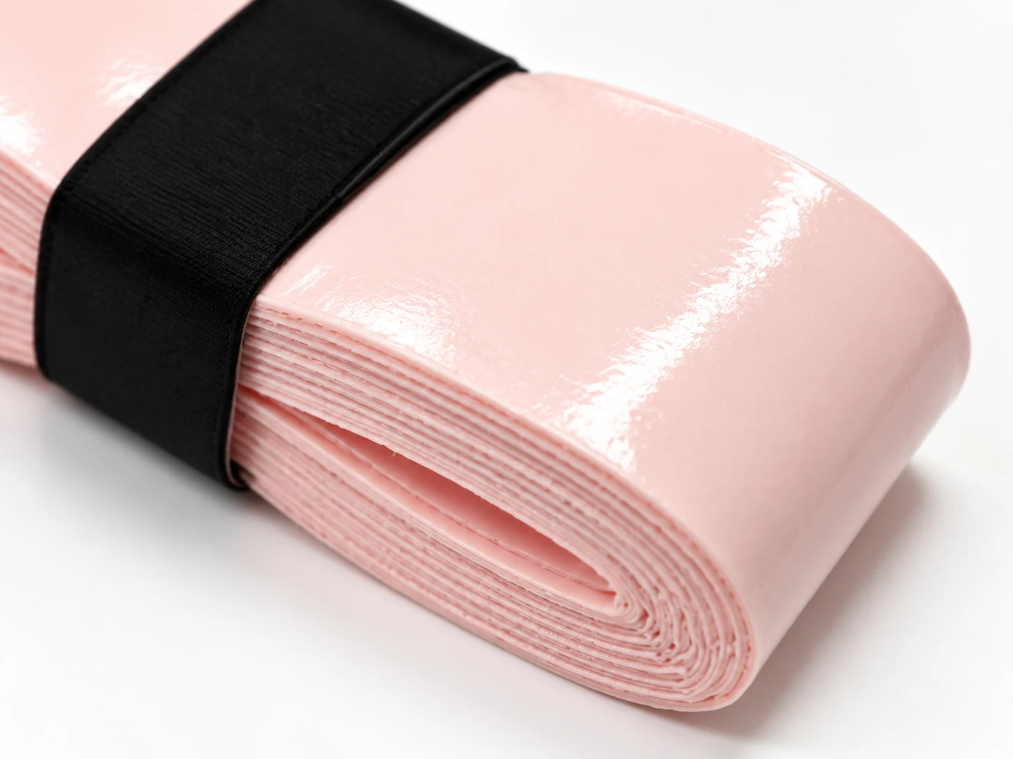 Close-up of the OG-T02 light pink soft-touch tacky overgrip surface and roll edge
